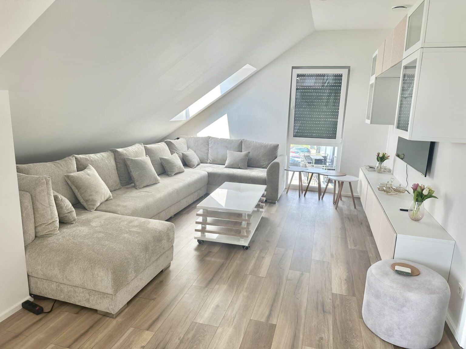 Großes L-förmiges Schlafsofa in einem Loft mit Dachschräge